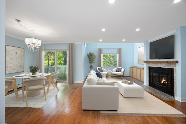 45 Ettl Ln Unit 301, Greenwich, CT 06831 - living room featuring a fireplace with flush hearth, plenty of natural light, a chandelier, wood finished floors, and crown molding