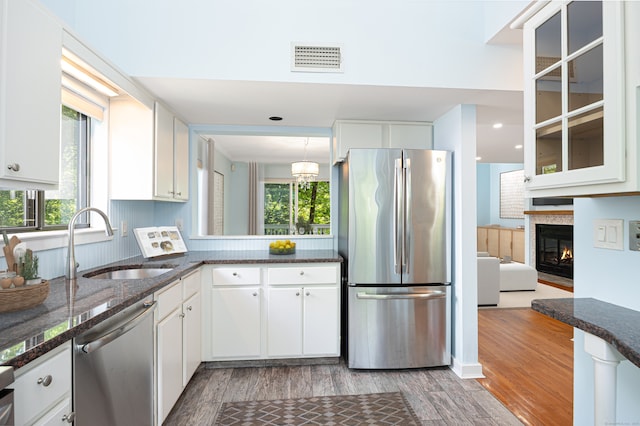 45 Ettl Ln Unit 301, Greenwich, CT 06831 - kitchen with stainless steel appliances, a sink, wood finished floors, and white cabinetry