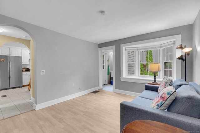 151 Alsace St, Bridgeport, CT 06604 - living area with arched walkways, light wood-style floors, and baseboards