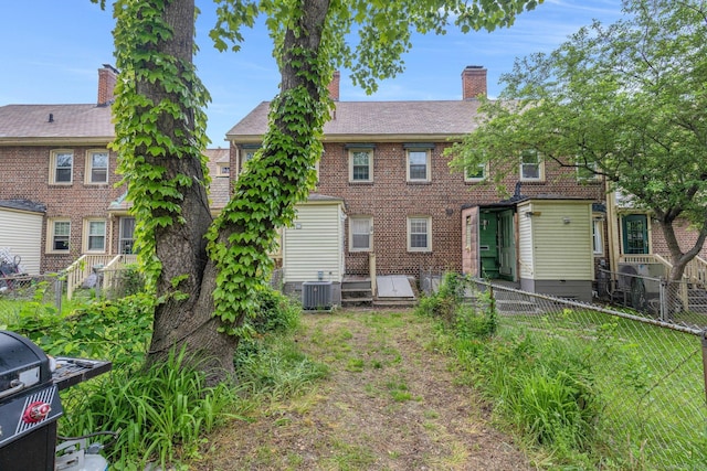 151 Alsace St, Bridgeport, CT 06604 - back of property with a fenced backyard, a chimney, brick siding, and central AC