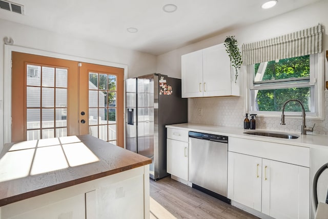 45 Coolidge Ave, Stamford, CT 06906 - kitchen featuring stainless steel appliances, a sink, light wood-type flooring, french doors, and tasteful backsplash