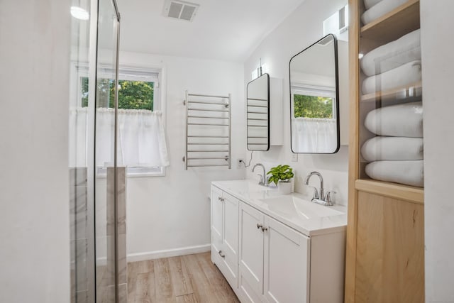 45 Coolidge Ave, Stamford, CT 06906 - full bathroom with a towel warmer, wood finished floors, double vanity, baseboards, and radiator heating unit