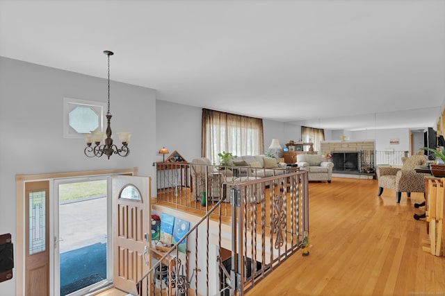 9 Marion Ct, North Haven, CT 06473 - entrance foyer with a chandelier, healthy amount of natural light, a stone fireplace, and light wood-style floors