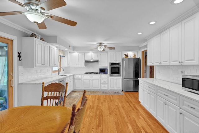 9 Marion Ct, North Haven, CT 06473 - kitchen with appliances with stainless steel finishes, a ceiling fan, decorative backsplash, plenty of natural light, and ornamental molding