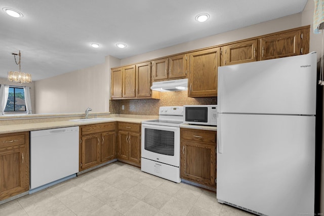 166 Old Brookfield Rd Unit 11C1, Danbury, CT 06811 - kitchen featuring white appliances, under cabinet range hood, decorative backsplash, brown cabinetry, and light countertops