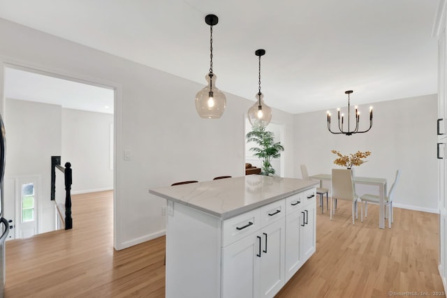 29 Magellan Dr, Milford, CT 06460 - kitchen featuring light wood finished floors, white cabinets, hanging light fixtures, a chandelier, and a kitchen island