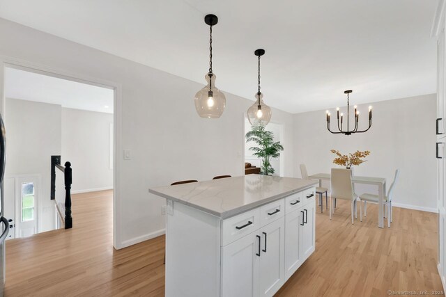 29 Magellan Dr, Milford, CT 06460 - kitchen featuring light wood finished floors, white cabinets, hanging light fixtures, a chandelier, and a kitchen island