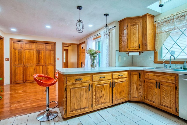 26 Lighthouse Hill Rd, Windsor, CT 06095 - kitchen with a sink, light countertops, brown cabinets, light wood-style flooring, and healthy amount of natural light