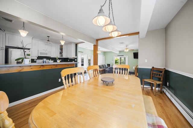 116 Grove St, Windsor Locks, CT 06096 - dining space with baseboard heating, light wood finished floors, beamed ceiling, a ceiling fan, and baseboards
