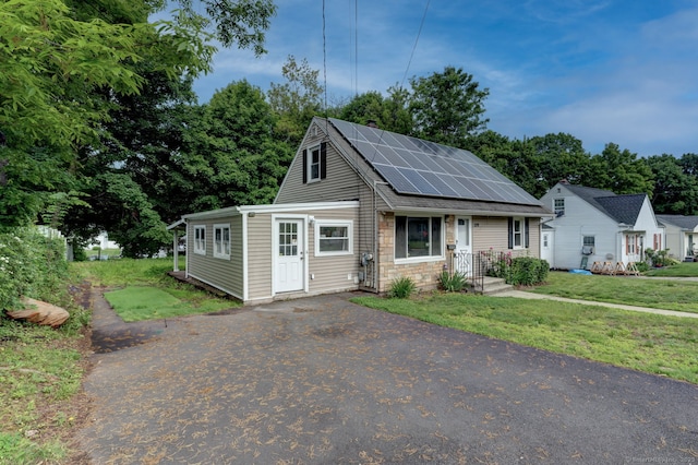 379 Belden Rd, Hamden, CT 06514 - view of front of home with roof mounted solar panels, a front yard, and stone siding