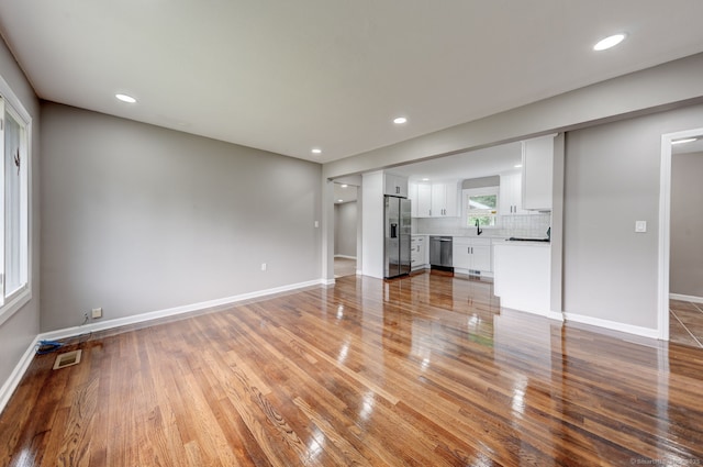 379 Belden Rd, Hamden, CT 06514 - unfurnished living room featuring light wood-style flooring, baseboards, a sink, and recessed lighting