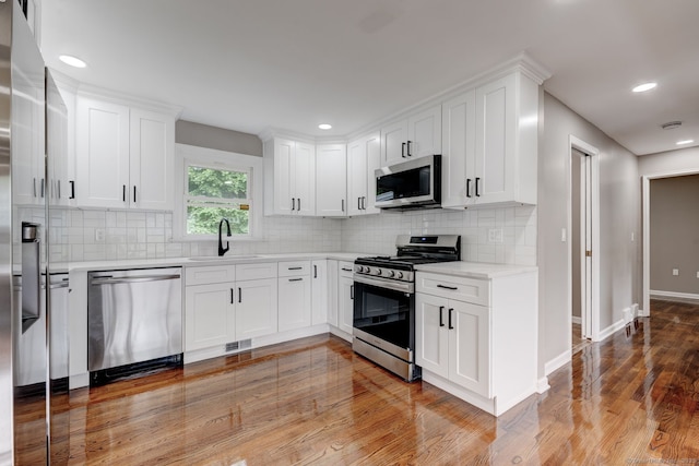 379 Belden Rd, Hamden, CT 06514 - kitchen with stainless steel appliances, a sink, light wood-style floors, tasteful backsplash, and recessed lighting