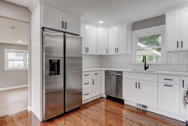 379 Belden Rd, Hamden, CT 06514 - kitchen featuring appliances with stainless steel finishes, a sink, light wood-style flooring, white cabinets, and recessed lighting