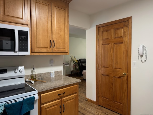 218 Fish Rock Rd, Southbury, CT 06488 - kitchen featuring white appliances, light wood finished floors, brown cabinetry, and baseboards