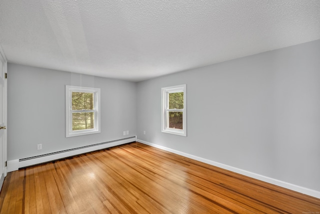 15 Indian Hill Rd, Canton, CT 06019 - spare room featuring a baseboard heating unit, plenty of natural light, hardwood / wood-style floors, baseboards, and a textured ceiling