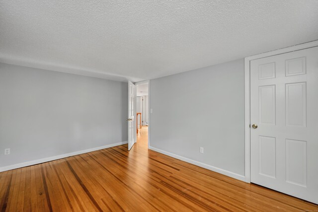 15 Indian Hill Rd, Canton, CT 06019 - unfurnished room with wood finished floors, a textured ceiling, and baseboards
