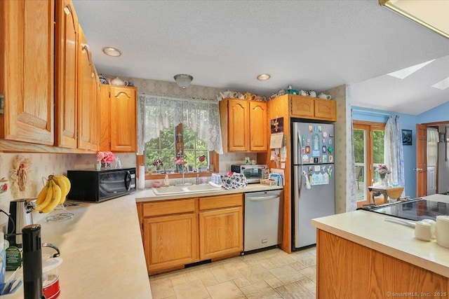 79 Carriage Dr E, Meriden, CT 06450 - kitchen with black appliances, light countertops, a sink, a skylight, and brown cabinetry