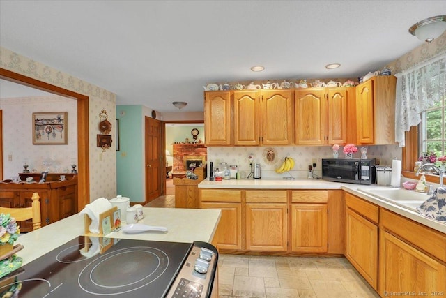 79 Carriage Dr E, Meriden, CT 06450 - kitchen featuring wallpapered walls, black microwave, light countertops, stove, and a sink
