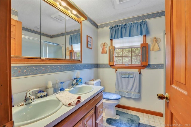 79 Carriage Dr E, Meriden, CT 06450 - full bathroom featuring double vanity, a shower with shower door, toilet, and a textured ceiling