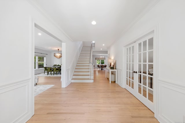 31 Pleasant St, Darien, CT 06820 - entrance foyer with crown molding, stairs, light wood-style flooring, a chandelier, and a decorative wall