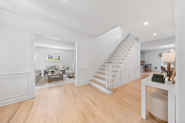 31 Pleasant St, Darien, CT 06820 - staircase featuring ornamental molding, a decorative wall, wood finished floors, recessed lighting, and wainscoting