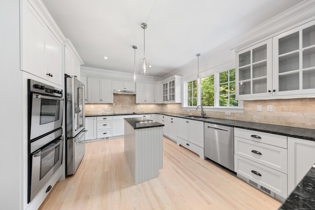 31 Pleasant St, Darien, CT 06820 - kitchen with appliances with stainless steel finishes, a sink, decorative backsplash, a kitchen island, and light wood-style flooring