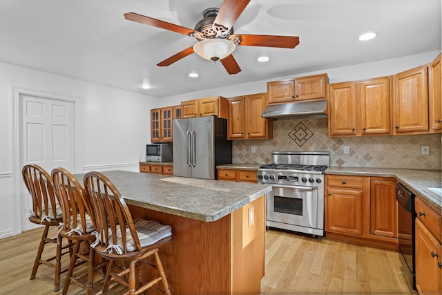 40A Mount Pleasant Rd, Newtown, CT 06470 - kitchen with appliances with stainless steel finishes, under cabinet range hood, light wood-style floors, a breakfast bar area, and a ceiling fan
