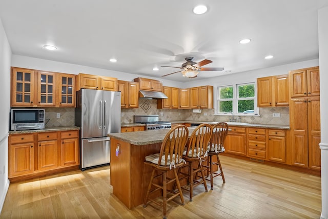 40A Mount Pleasant Rd, Newtown, CT 06470 - kitchen featuring appliances with stainless steel finishes, under cabinet range hood, light wood finished floors, a kitchen breakfast bar, and recessed lighting