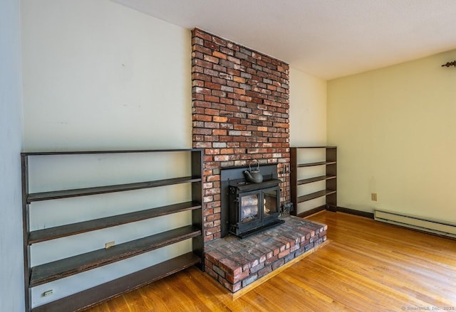 58 Wildwood Ln, Durham, CT 06422 - living room featuring a wood stove, wood finished floors, baseboard heating, and baseboards