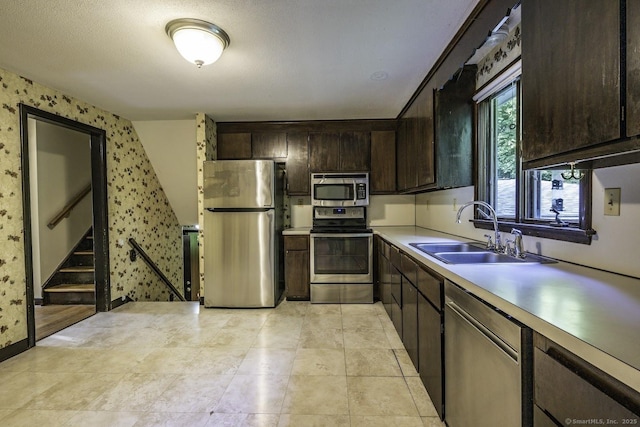 58 Wildwood Ln, Durham, CT 06422 - kitchen featuring appliances with stainless steel finishes, a sink, wallpapered walls, dark brown cabinetry, and light countertops