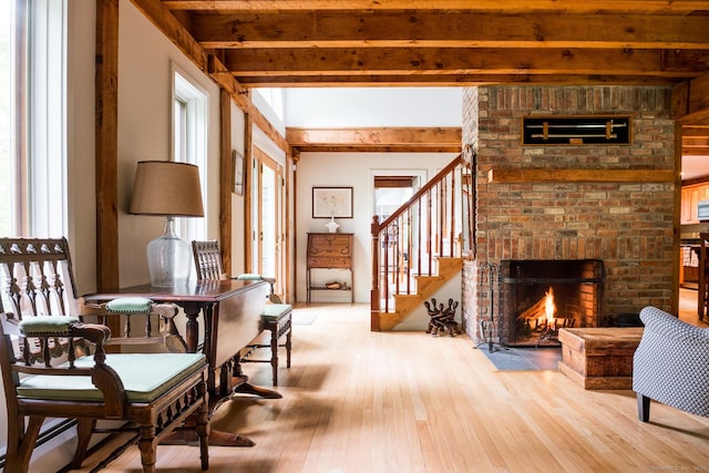 1900 Home Rd, Great Barrington, MA 01230 - living area featuring hardwood / wood-style flooring, a brick fireplace, beam ceiling, stairs, and a baseboard radiator