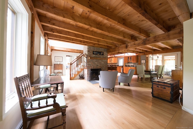 1900 Home Rd, Great Barrington, MA 01230 - living room featuring light wood-style floors, wooden ceiling with exposed beams, a fireplace, a chandelier, and a baseboard heating unit