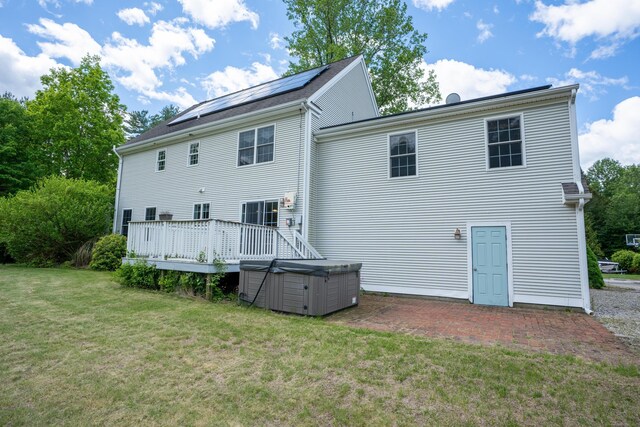 2 Acorn Dr, East Haddam, CT 06423 - back of house featuring a hot tub, a lawn, roof mounted solar panels, a patio, and a deck