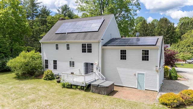 2 Acorn Dr, East Haddam, CT 06423 - back of property featuring a yard, solar panels, a shingled roof, and a wooden deck