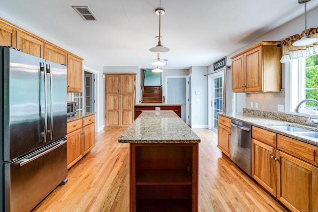 2 Acorn Dr, East Haddam, CT 06423 - kitchen with stainless steel appliances, a sink, a center island, light wood finished floors, and baseboards