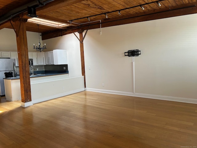 68 Thermos Ave Unit 410E, Norwich, CT 06360 - unfurnished room featuring track lighting, a wooden ceiling with exposed beams, light wood finished floors, and a chandelier