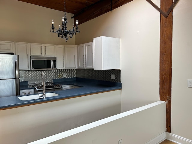 68 Thermos Ave Unit 410E, Norwich, CT 06360 - kitchen featuring stainless steel appliances, dark countertops, tasteful backsplash, white cabinetry, and a wood ceiling with exposed beams