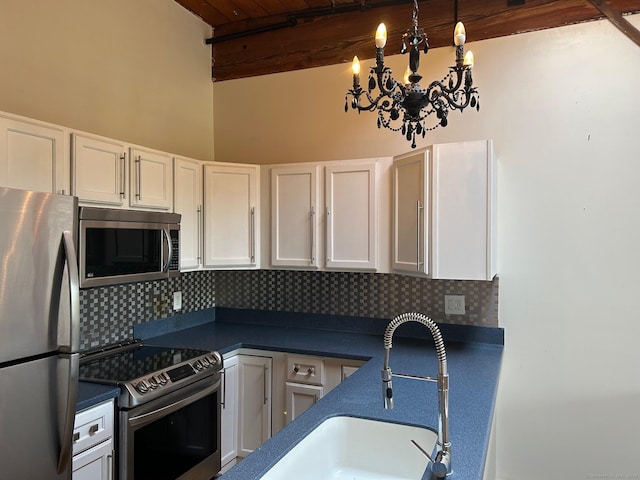 68 Thermos Ave Unit 410E, Norwich, CT 06360 - kitchen with appliances with stainless steel finishes, decorative backsplash, dark countertops, white cabinets, and a chandelier