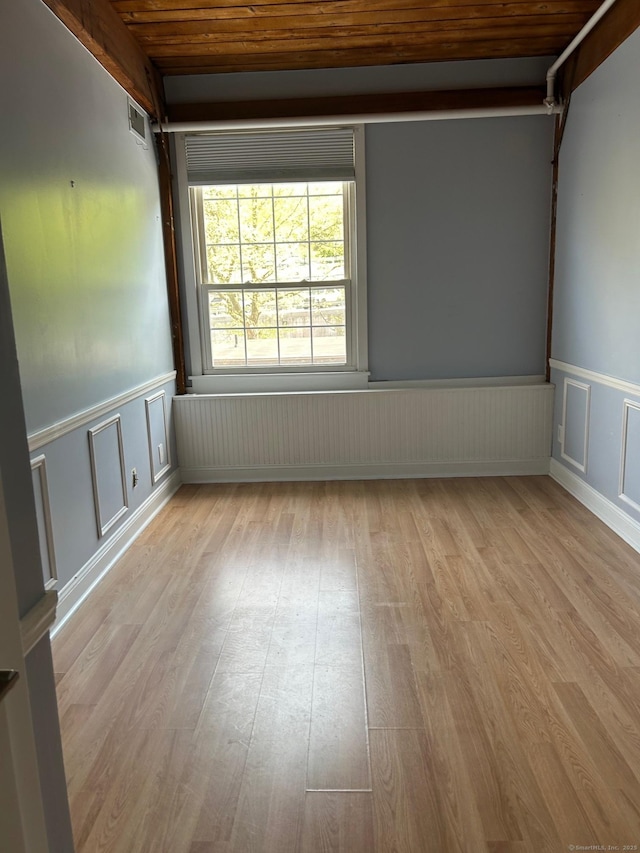 68 Thermos Ave Unit 410E, Norwich, CT 06360 - unfurnished room featuring wooden ceiling, light wood-style flooring, wainscoting, and a decorative wall