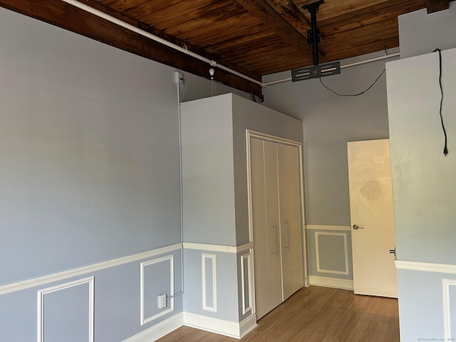 68 Thermos Ave Unit 410E, Norwich, CT 06360 - spare room featuring a wooden ceiling with exposed beams, wood finished floors, a wainscoted wall, track lighting, and a decorative wall