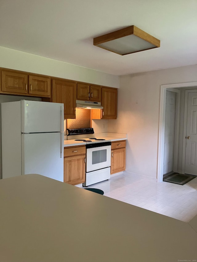 116 Taylor Rd, New Milford, CT 06776 - kitchen with white appliances, under cabinet range hood, light countertops, and brown cabinetry