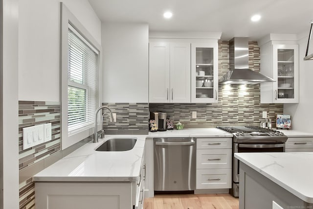 1 Howard Ave Unit C2, Norwalk, CT 06855 - kitchen with appliances with stainless steel finishes, wall chimney range hood, a sink, white cabinetry, and light stone countertops