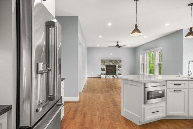 14 Fiddlehead Pl, Suffield, CT 06078 - kitchen with stainless steel appliances, a ceiling fan, a fireplace, white cabinets, and a sink