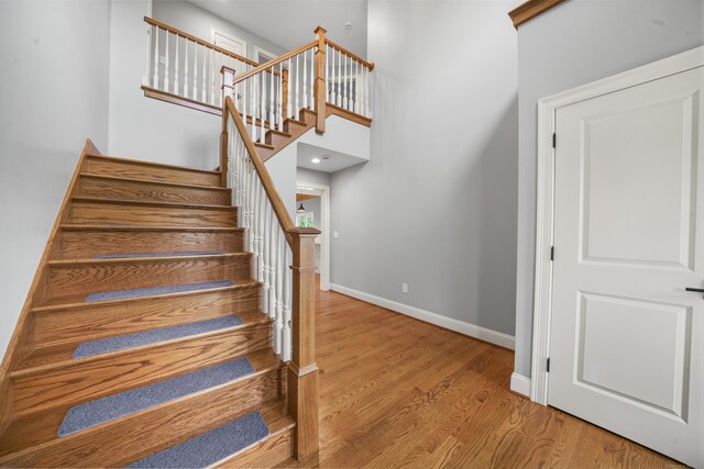 14 Fiddlehead Pl, Suffield, CT 06078 - staircase featuring baseboards, wood finished floors, and a high ceiling