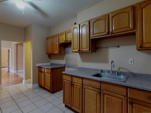 24 Townley St, Hartford, CT 06105 - kitchen with a sink, a ceiling fan, brown cabinets, light tile patterned floors, and baseboards