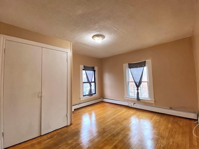 24 Townley St, Hartford, CT 06105 - unfurnished bedroom with wood finished floors, a textured ceiling, baseboard heating, and a closet