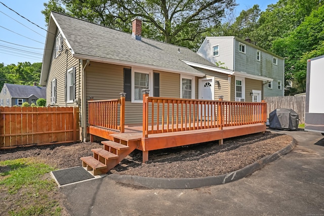 355 Farmington Ave, Bristol, CT 06010 - back of property featuring roof with shingles, a chimney, and a deck