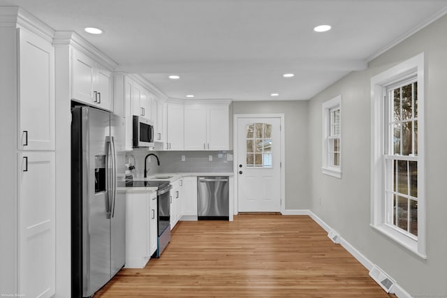 14 Denmore Ln, Old Saybrook, CT 06475 - kitchen featuring stainless steel appliances, light wood-style flooring, light countertops, recessed lighting, and white cabinetry
