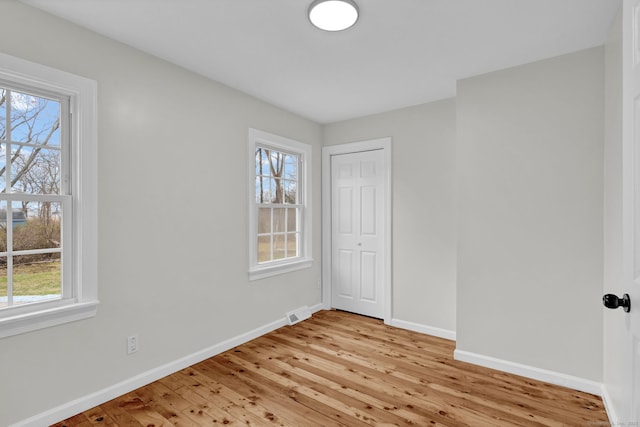 14 Denmore Ln, Old Saybrook, CT 06475 - unfurnished bedroom with multiple windows, light wood-style flooring, and a closet