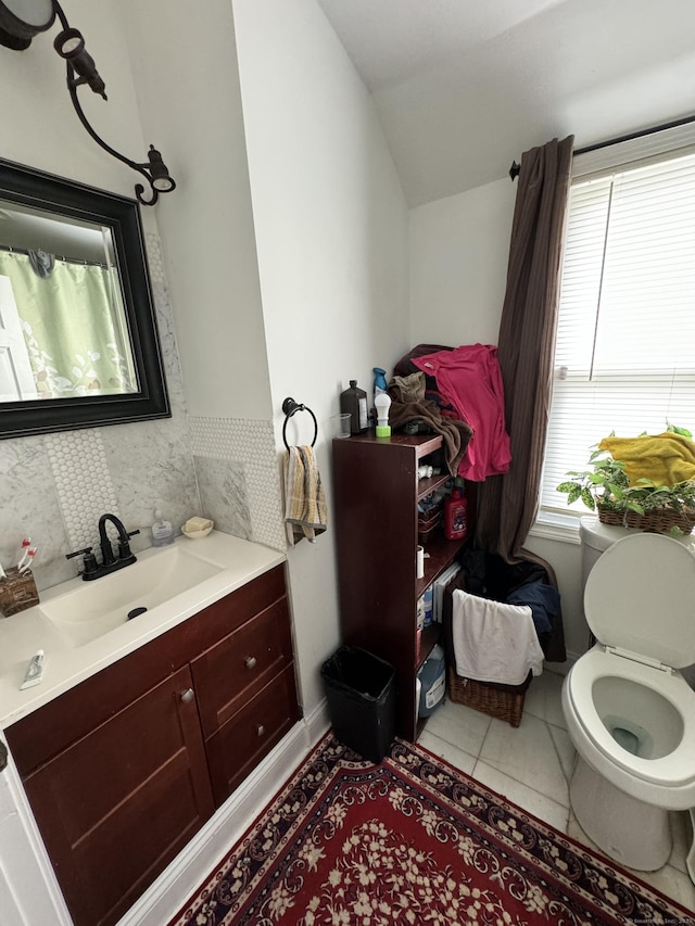 385 Chamberlain Ave, Bridgeport, CT 06606 - full bath with lofted ceiling, toilet, vanity, backsplash, and tile patterned floors